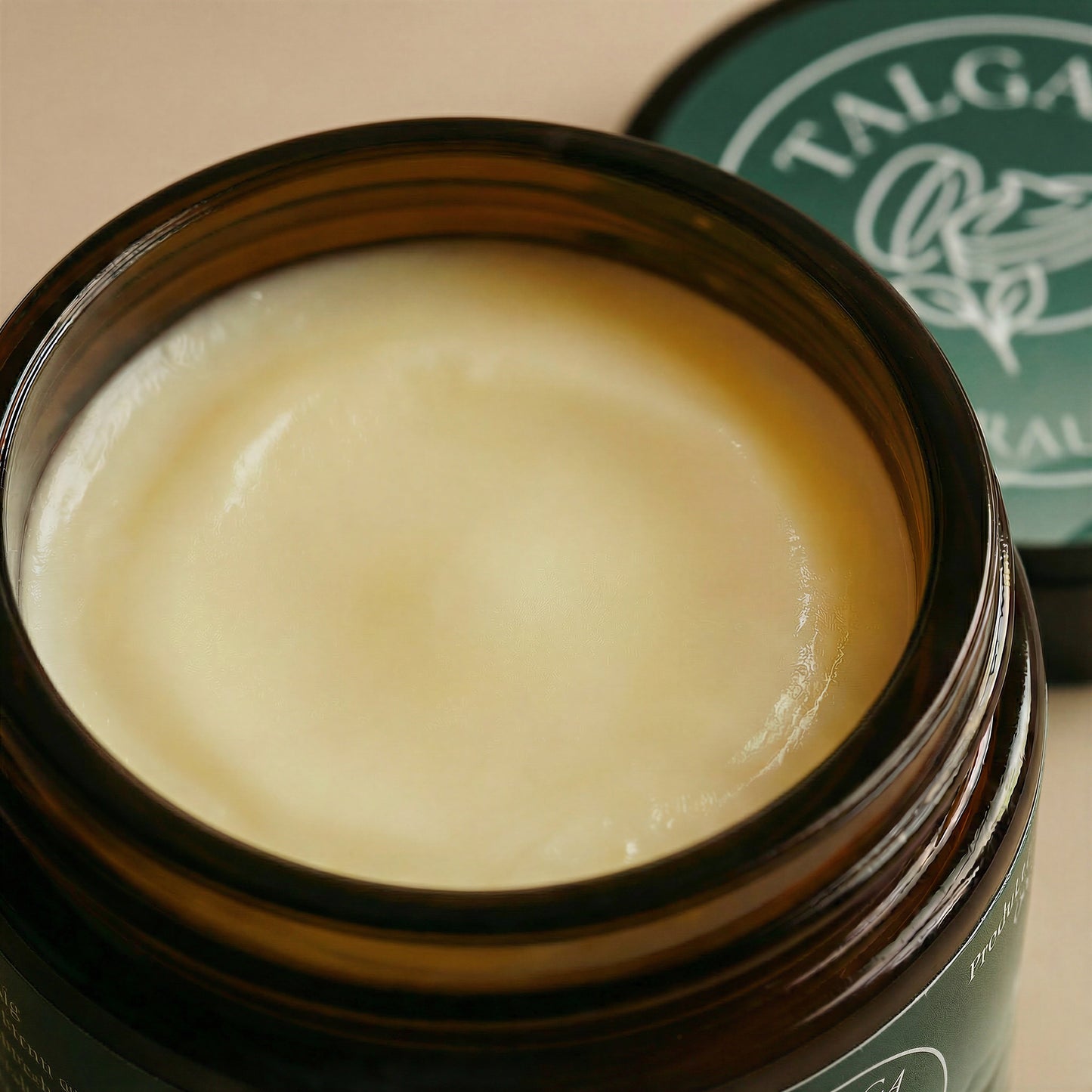 Close-up of Talga Rich cream texture in an open amber glass jar, with the lid blurred behind.